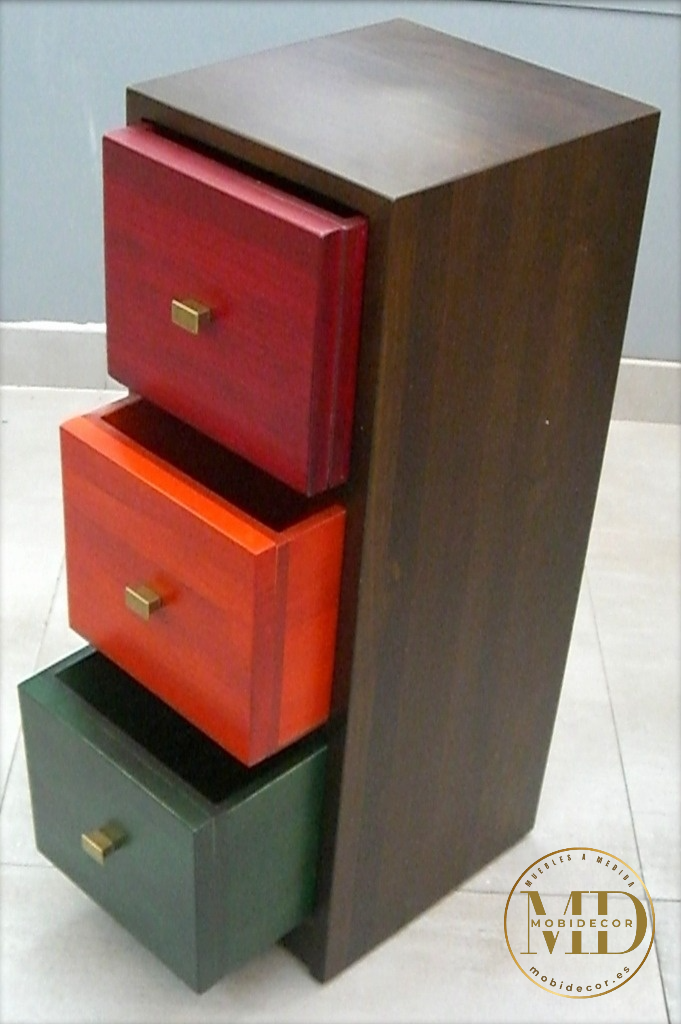 Mesilla de noche de madera con tres cajones y tiradores metálicos.